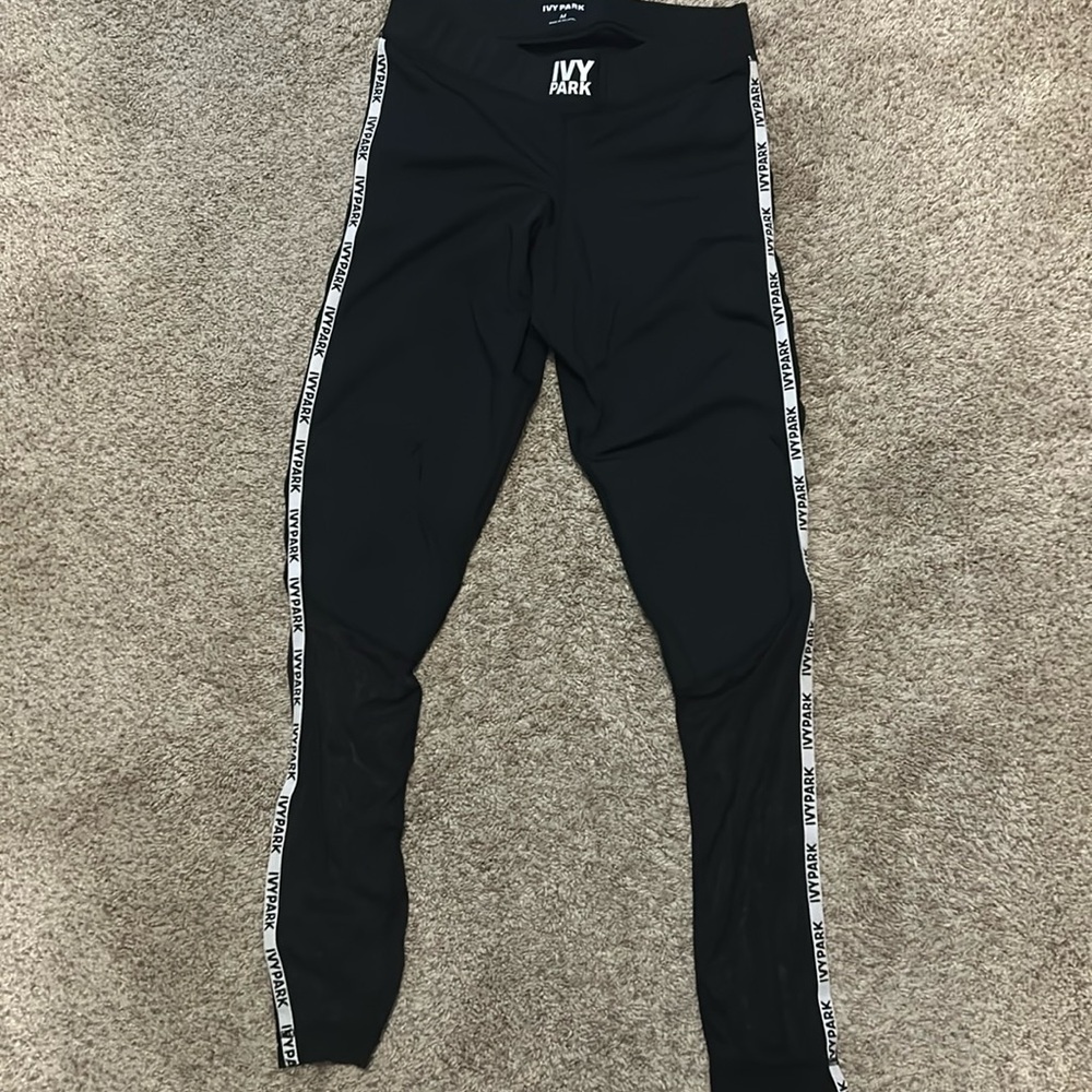 Ivy Park leggings in black with logo down the sides of the legs.